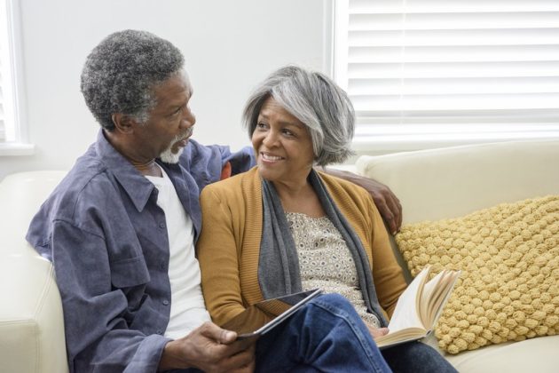 Senior African American couple on sofa smiling affectionately