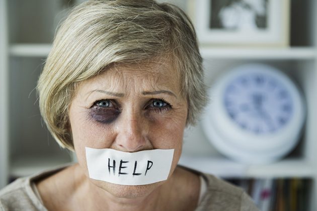 Senior woman with black eye and tape on her mouth, victim of domestic violence
