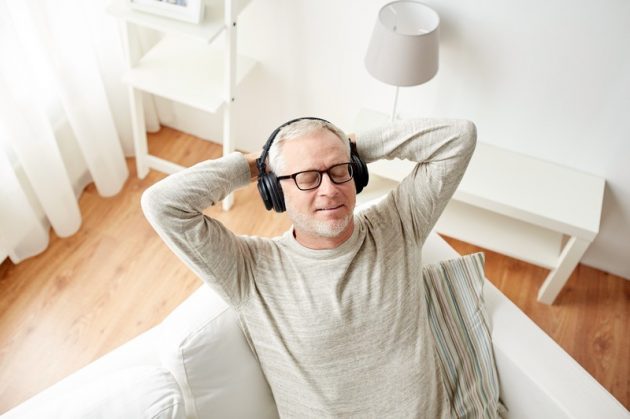 happy man in headphones listening to music at home